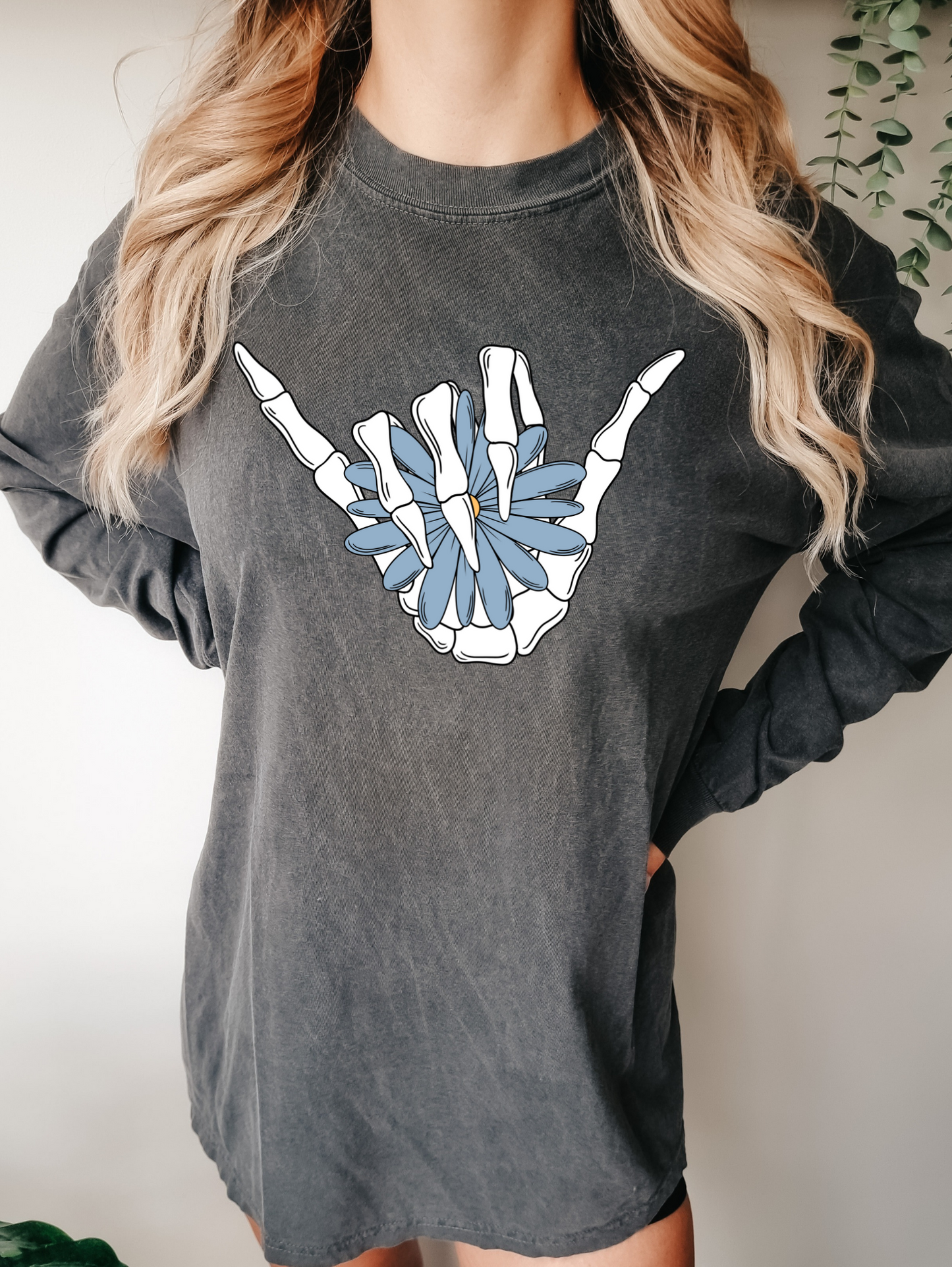 Bone hand holding blue flower